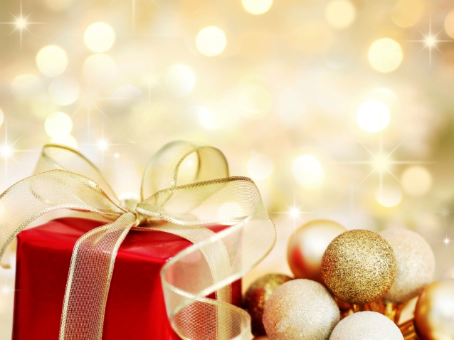 Christmas gift and baubles on defocused lights background